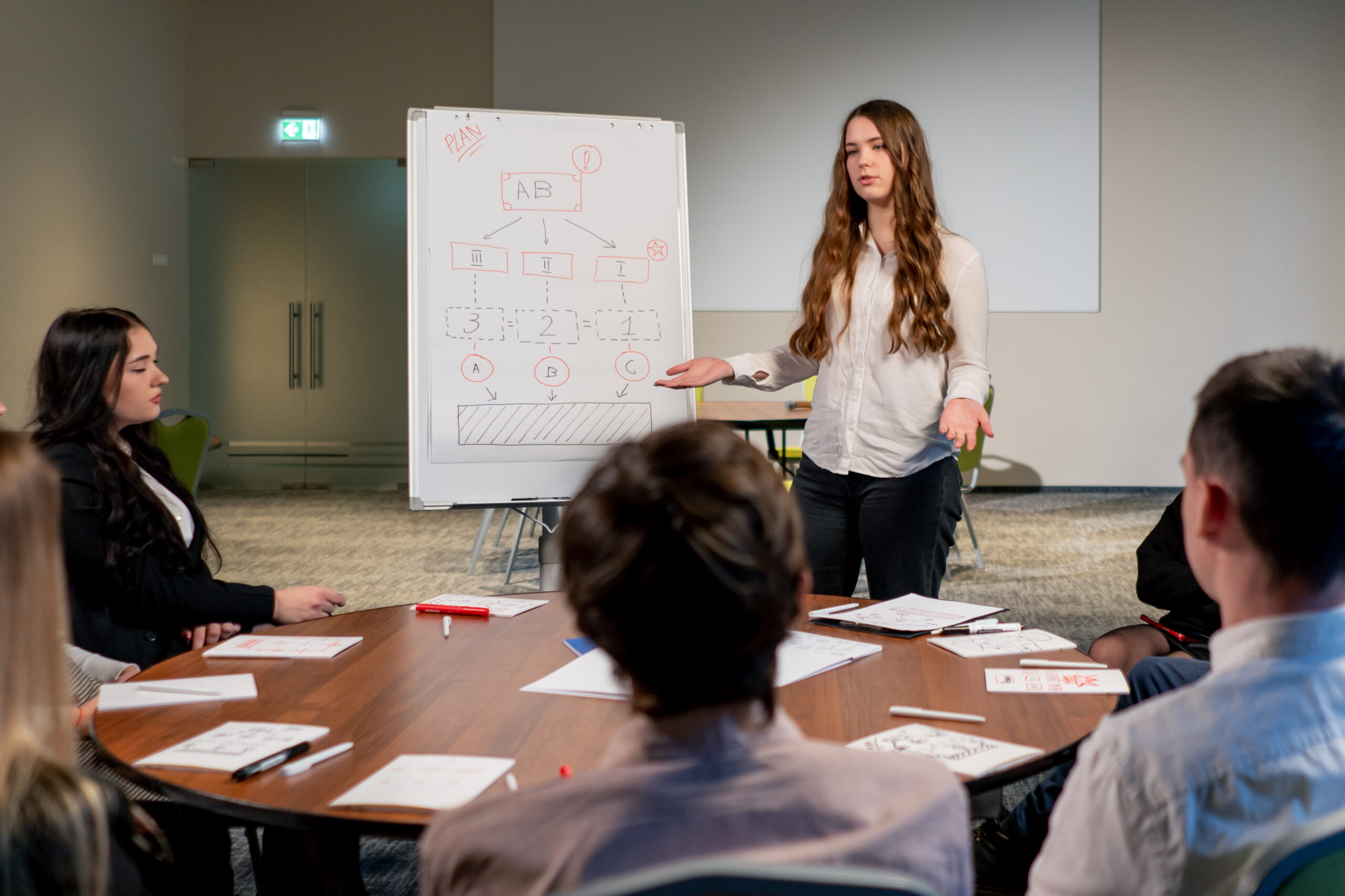 business conference or meeting at the hotel the girl on the flipchart shows the development plan for company