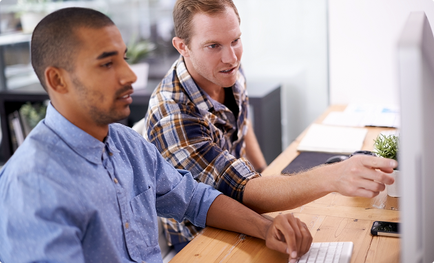 twee personen op de afbeelding die wijzen naar een computerscherm